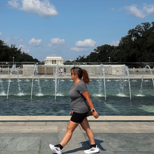 A woman walks near the fountain at the WWII Memorial, in Washington, Wednesday, July 29, 2026. (AP Photo/Rahmat Gul)