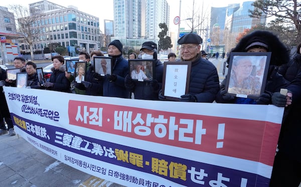 FILE - Family members of forced labor victims during the Japan's colonial period arrive at the Supreme Court in Seoul, South Korea, on Dec. 21, 2023. The sign reads "Mitsubishi Heavy Industries should compensate and apologize." (AP Photo/Ahn Young-joon, File)