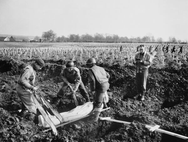 FILE - An American soldier, identified as Patsy Caliendo, is laid to rest in the largest Allied military cemetery on the Western Front March 14, 1945, in Henri-Chapelle, Belgium. (AP Photo/William C. Allen, File)