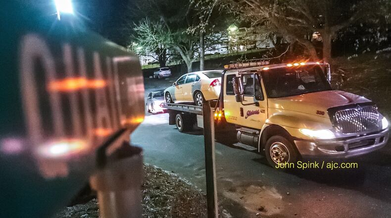 A car is towed from an apartment complex on Quail Run off Snapfinger Woods Road Monday morning after a deadly shooting in the parking lot.