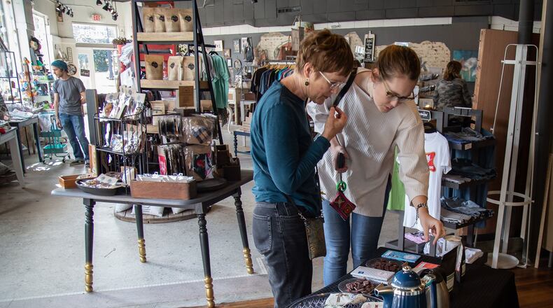 Claudia McDavid and her daughter Olivia McDavid try the free chocolate and tea samples while shopping at Garage Door Studio during Small Business Saturday in Avondale Estates. STEVE SCHAEFER / SPECIAL TO THE AJC