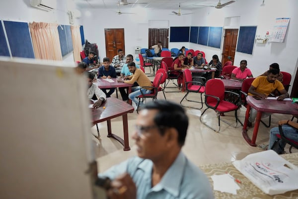 Vilvaraj Vinothan, 30, center left in brown shirt, who works for a demining agency, attends a Sinhala language course as a part of a vocational transition program in Vavuniya, Sri Lanka, Thursday, March 27, 2025. (AP Photo/Eranga Jayawardena)