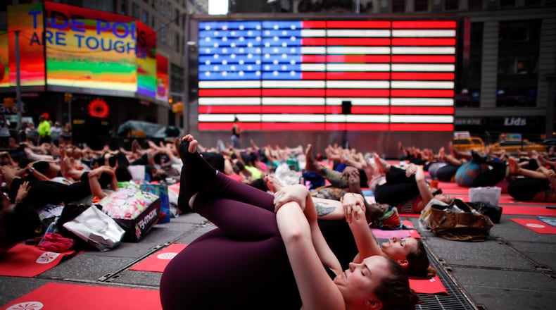 NEW YORK, NY - JUNE 21: People do yoga in Times Square as part of the International Day of Yoga celebration on the Summer Solstice June 21, 2015 in New York City. One hundred and ninety-two countries joined in for a mass yoga session to mark the United Nations declared, International Yoga Day. (Photo by Kena Betancur/Getty Images)