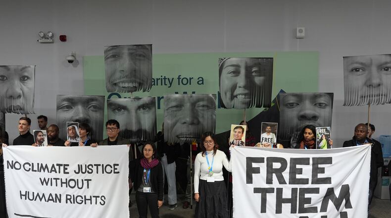 FILE - Demonstrators hold signs with images of environmental defenders during the COP29 U.N. Climate Summit, Nov. 20, 2024, in Baku, Azerbaijan. (AP Photo/Joshua A. Bickel, File)