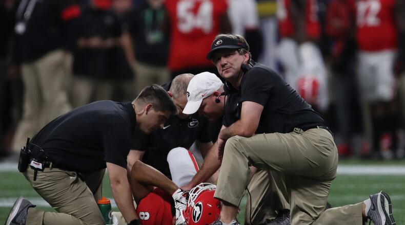 Coach Kirby Smart and trainers tend to injured Georgia Bulldogs wide receiver Dominick Blaylock (8) during the first half of the Georgia vs. LSU SEC Football Championship game at Mercedes-Benz Stadium in Atlanta. Alyssa Pointer / alyssa.pointer@ajc.com