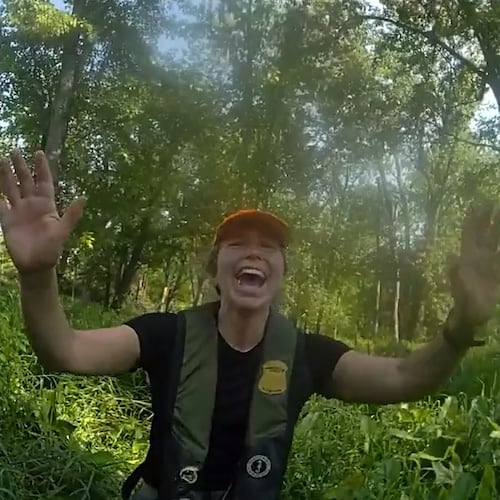 This image made from video provided by the Michigan Department of Natural Resources shows conservation officer Anna Cullen celebrating on Friday, Aug. 7, 2026, in Twin Lake, Mich., as a search and rescue team found two women and a child who had been missing after taking a river tubing trip. (