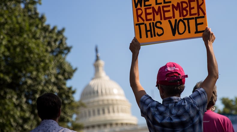 A protester holds up a sign during a rally against the GOP health care plan, on Capitol Hill, July 26, 2017 in Washington, DC. (Photo by Drew Angerer/Getty Images)