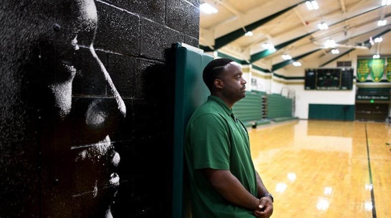 Athletic Director Willie McGee stands next to a mural of former high school teamate and childhood friend LeBron James in the gym at St. Vincent-St. Mary High School in Akron, Ohio. (Wally Skalij/Los Angeles Times/TNS)