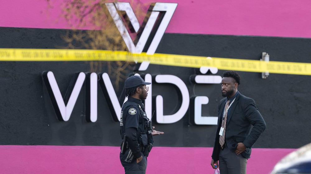 An Atlanta police officer and detective stand in the parking lot of the Vivide nightclub on Marietta Boulevard following a fatal stabbing early Wednesday, Nov. 26, 2025, in Blandtown. (Ben Hendren for the AJC)