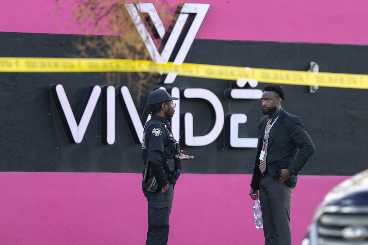 An Atlanta police officer and detective stand in the parking lot of the Vivide nightclub on Marietta Boulevard following a fatal stabbing early Wednesday, Nov. 26, 2025, in Blandtown. (Ben Hendren for the AJC)