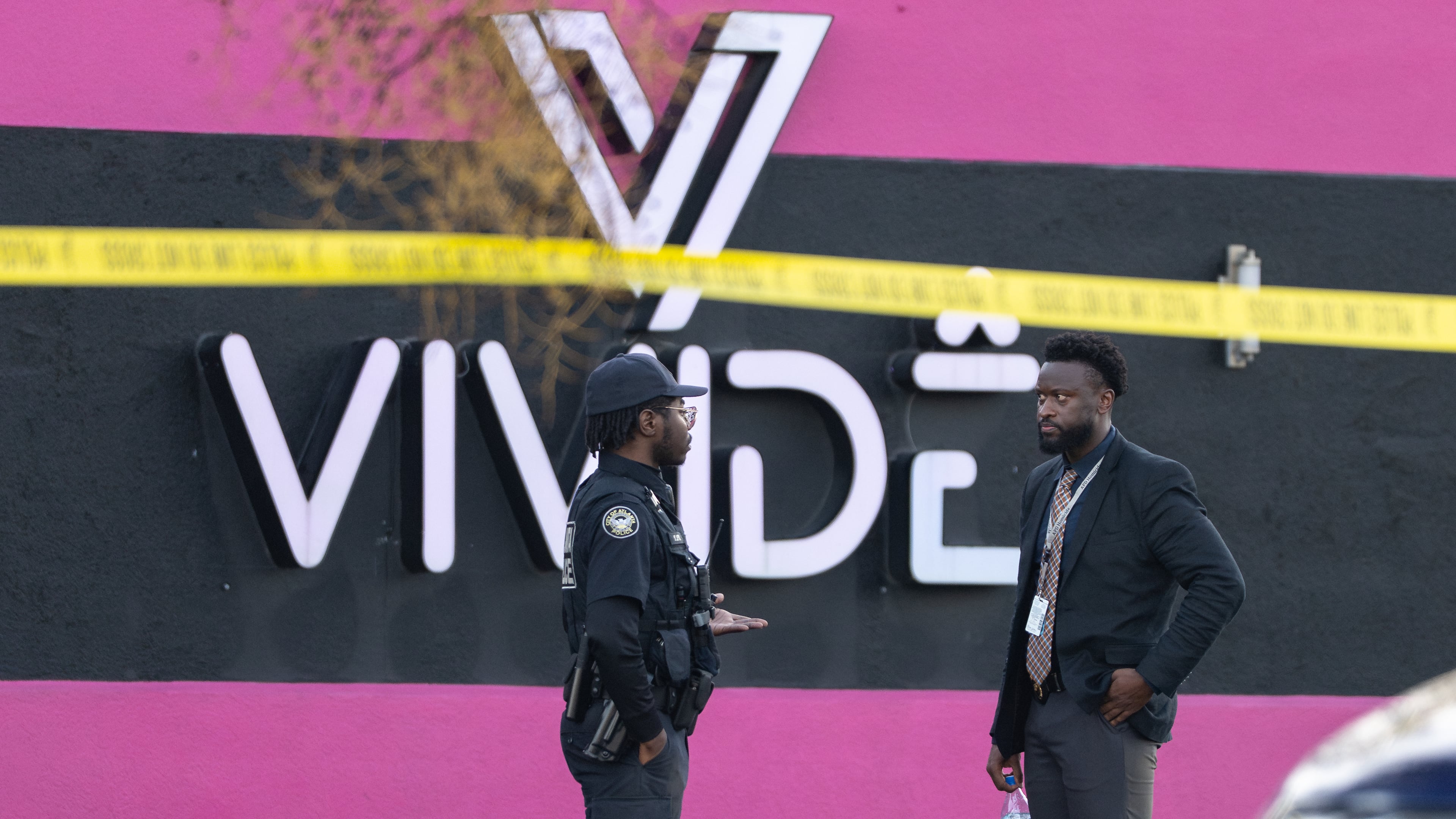 An Atlanta police officer and detective stand in the parking lot of the Vivide nightclub on Marietta Boulevard following a fatal stabbing early Wednesday, Nov. 26, 2025, in Blandtown. (Ben Hendren for the AJC)