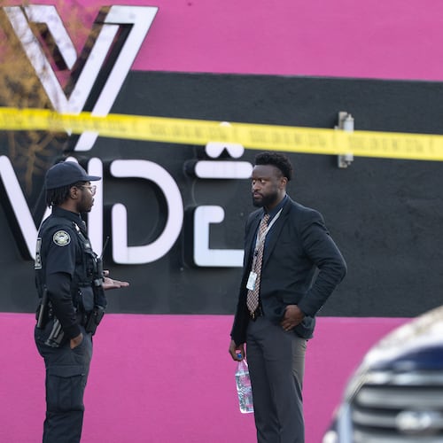 An Atlanta police officer and detective stand in the parking lot of the Vivide nightclub on Marietta Boulevard in Blandtown following a fatal stabbing early Wednesday. (Ben Hendren for the AJC)
