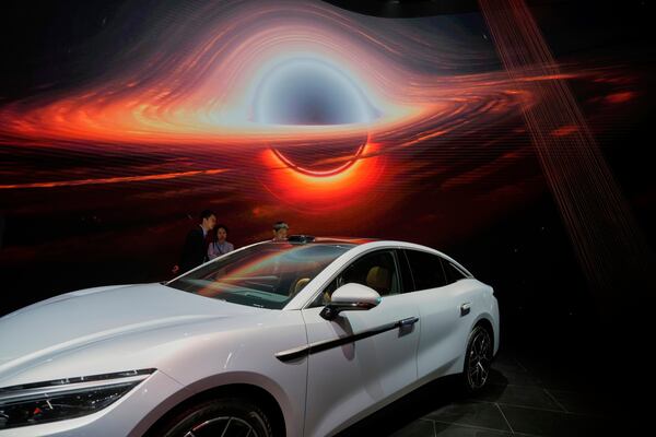 Visitors look at the Han L EV model from BYD during the Shanghai auto show on Wednesday, April 23, 2025. (AP Photo/Ng Han Guan)