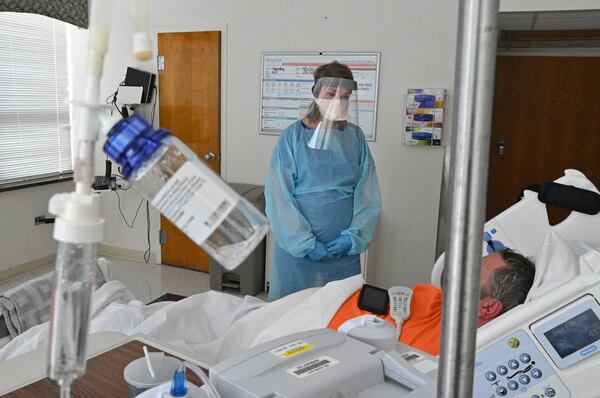 Registered ICU nurse Katie Van Hook checks on a COVID-19 patient at Memorial Health's main hospital building in Savannah. In Georgia, COVID-19 hospitalizations reached their peak just before Labor Day and had declined some 10% by Sept. 13. But deaths are still sharply inclining. (Hyosub Shin / Hyosub.Shin@ajc.com)