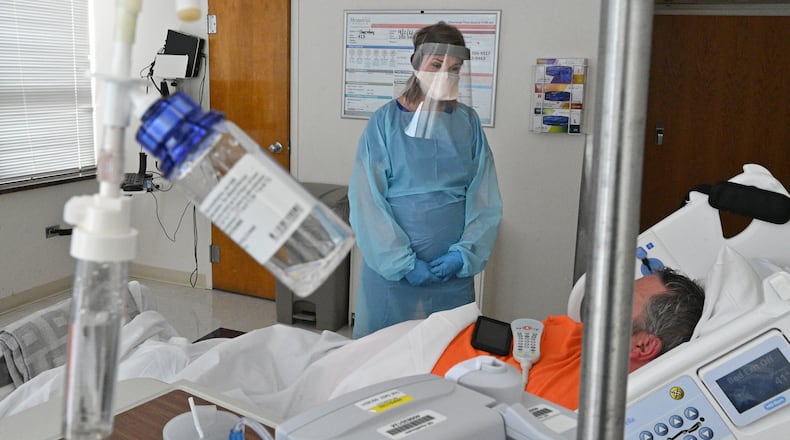 Registered ICU nurse Katie Van Hook checks on a COVID-19 patient at Memorial Health's Heart and Vascular Institute in Savannah. (Hyosub Shin / Hyosub.Shin@ajc.com)