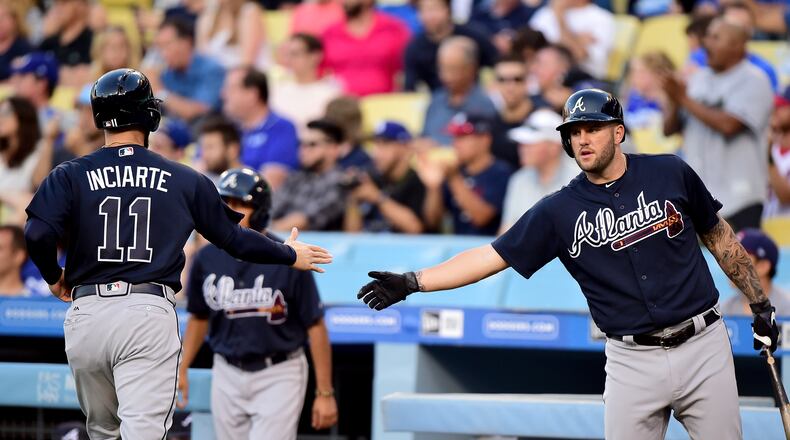 Braves high-five at the plate against the Los Angeles Dodgers during the first inning at Dodger Stadium on July 20, 2017 in Los Angeles, California. (Photo by Harry How/Getty Images)