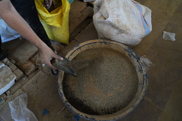 Displaced Palestinians purchase ground lentils as a substitute for making bread due to a shortage of flour in the Gaza Strip, in Khan Younis, on Sunday, May 11, 2025. (AP Photo/Abdel Karem Hanna)