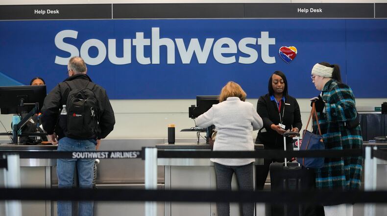 Travelers check in with Southwest Airlines at Midway International Airport, Tuesday, Jan. 27, 2026, in Chicago. (AP Photo/Erin Hooley)