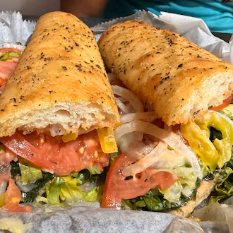A large Italian sandwich wrapped in paper.