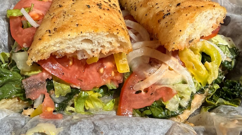 A large Italian sandwich wrapped in paper.