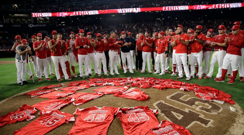 Members of the Los Angeles Angels place their jerseys with No. 45 in honor of pitcher Tyler Skaggs on the mound after a combined no-hitter against the Seattle Mariners during a baseball game Friday, July 12, 2019, in Anaheim, Calif. The Angels won 13-0. (AP Photo/Marcio Jose Sanchez)