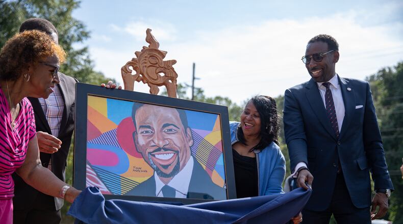 Atlanta Mayor Andre Dickens (right) along with his mother, Sylvia Dickens (left) and Council member Andrea Boone (center) unveil a new mural featuring the mayor in Adamsville on Oct. 5, 2023. (Riley Bunch/riley.bunch@ajc.com)