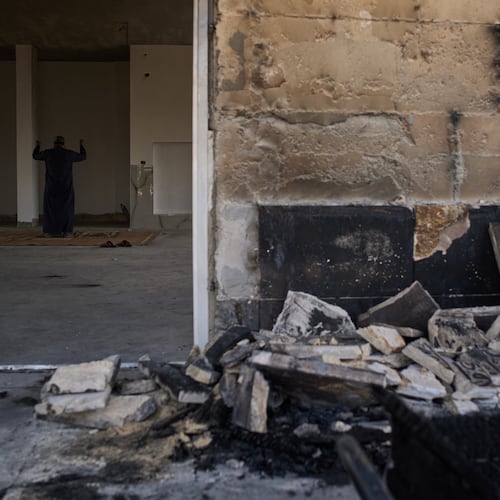 A Palestinian man prays inside a mosque that was burned during an attack by Israeli settlers early in the morning in the West Bank village of Qusra, Sunday, July 26, 2026. (AP Photo/Leo Correa)
