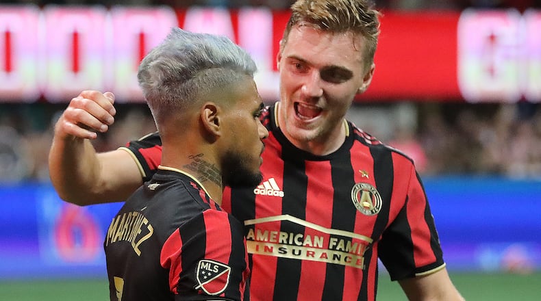 Atlanta United midfielder Julian Gressel (right) is the first to celebrate with forward Josef Martinez after a penalty kick for his second goal against New York City FC during a 2-1 victory in their soccer match on Sunday, Aug. 11, 2019, at Mercedes-Benz Stadium in Atlanta.