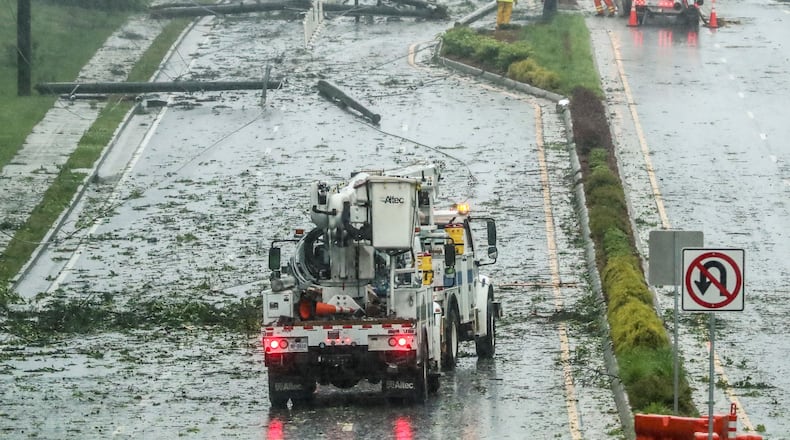 Power crews had their hands full restoring power and cleaning up downed trees and power lines along Old Alabama Road between Buice Road and Medlock Road after power lines came down in the Johns Creek area. Severe storms Friday resulted in flooding and sinkholes on metro Atlanta roads. On Saturday, the National Weather Service confirmed a tornado touched down in Hall County on Friday. (Photo: JOHN SPINK/JSPINK@AJC.COM)