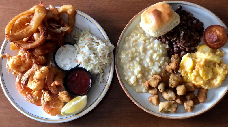 This takeout order from the Colonnade includes fried shrimp with onion rings and coleslaw, and a veggie plate with creamed corn, crowder peas, seasonal squash, fried okra, yeast roll and a corn muffin. / Wendell Brock for The Atlanta Journal-Constitution