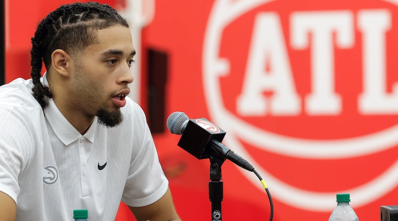 Seth Lundy speaks during introductory media gathering Monday. Water bottle partially hides Lundy's signature tattoo. (Natrice Miller/ Natrice.miller@ajc.com)