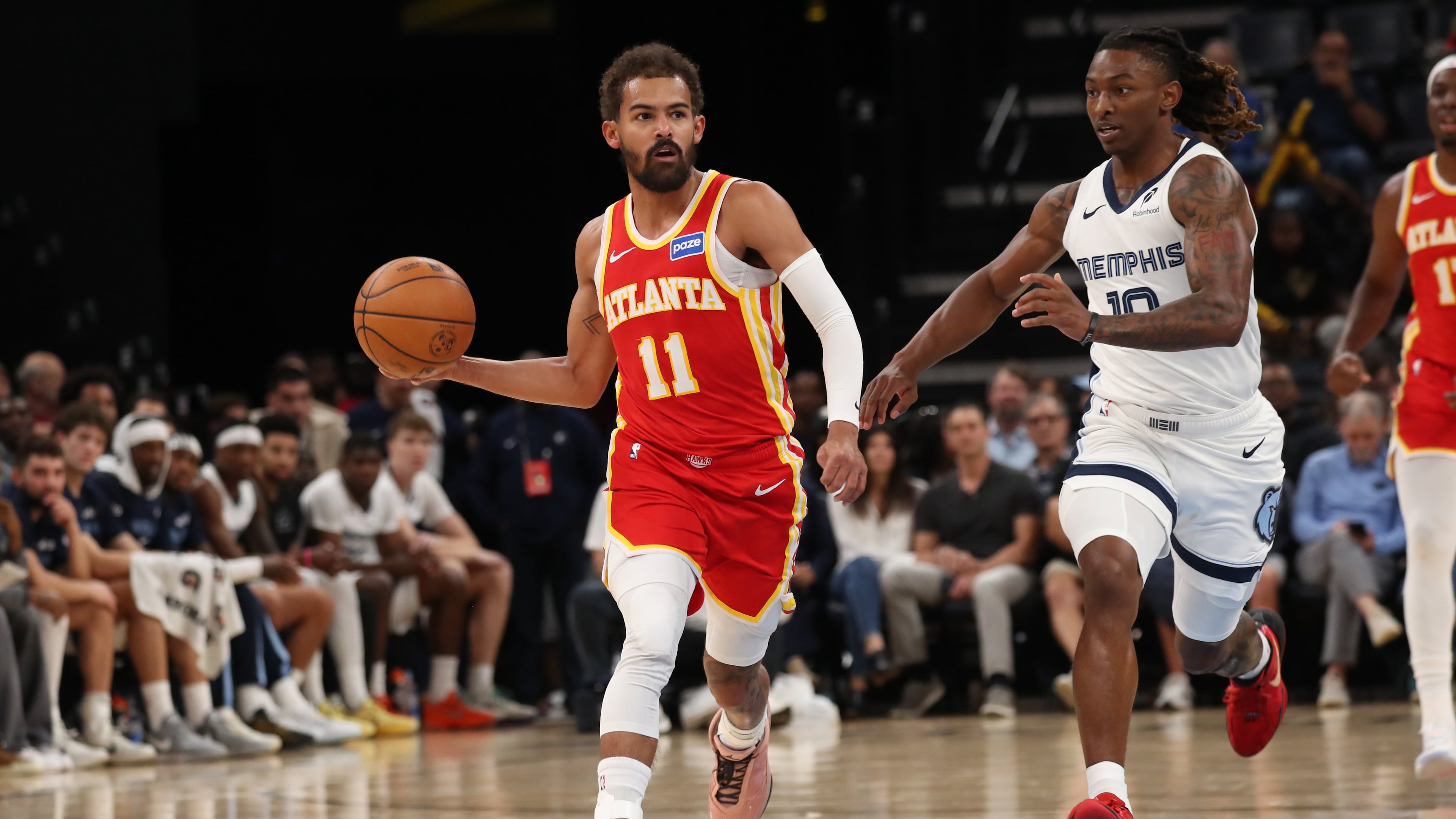 Atlanta Hawks guard Trae Young (11) drives with the ball while defended by Memphis Grizzlies guard Javon Small (10) in the first half of a preseason NBA basketball game Saturday, Oct. 11, 2025, in Memphis, Tenn. (AP Photo/Nikki Boertman)