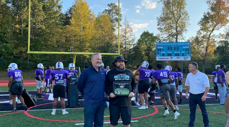 Former South Atlanta coach Brad Stephens (right), accepting the Georgia High School Football Daily Team of the Week award following a win over Pace Academy last season, is the new head coach at Chapel Hill.