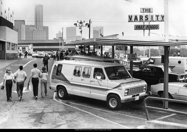 Cars park outside the Varsity Drive-In restaurant, with the downtown skyline in the background in 1985. (AJC FILE)