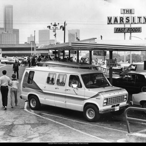 Cars parked outside of the Varsity Drive-In restaurant, with the downtown skyline in the background in 1985. (AJC file)