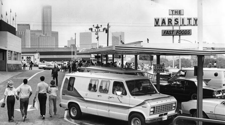 Cars parked outside of the Varsity Drive-In restaurant, with the downtown skyline in the background in 1985. (AJC file)