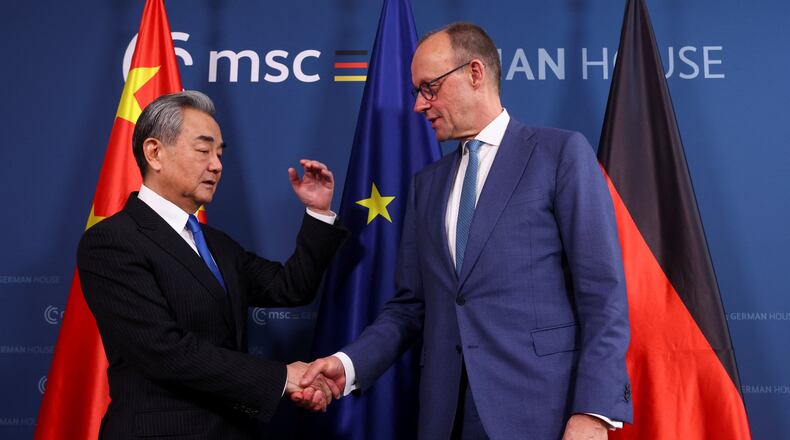 German Chancellor Friedrich Merz, right, shakes hands with Chinese Foreign Minister Wang Yi as they meet during the Munich Security Conference (MSC) in Munich, Germany, Saturday Feb. 14, 2026. (Thilo Schmuelgen/Pool Photo via AP)