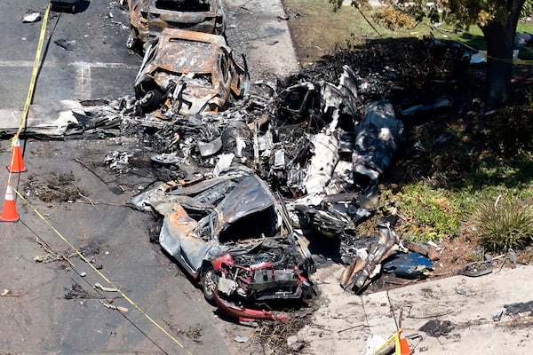 Debris covers the ground after a small plane crashed into a San Diego neighborhood, setting homes and cars on fire and forcing evacuations early Thursday, May 22, 2025. (AP Photo/William Liang)
