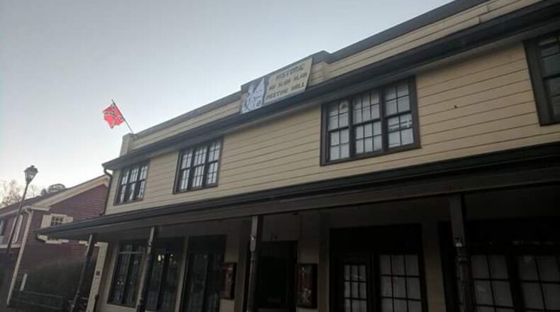 A Confederate flag, a Ku Klux Klan flag and a sign were placed on a building in Dahlonega overnight. (Credit: Channel 2 Action News)