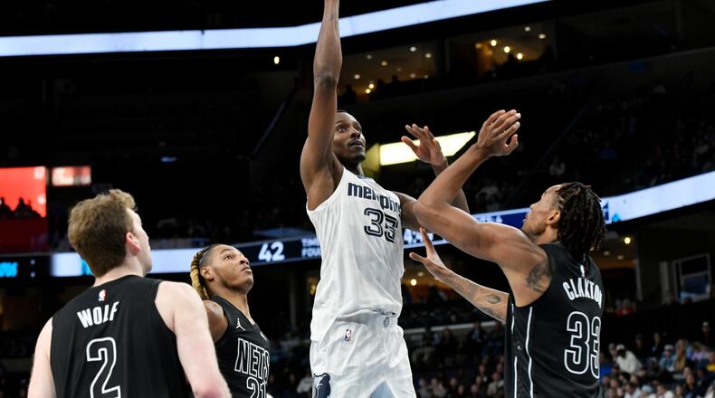 Then-Grizzlies center Christian Koloko (center) shoots over Nets players Danny Wolf (from left), Noah Clowney and Nic Claxton on Sunday, Jan. 11, 2026, in Memphis, Tenn. Koloko has had quite the welcome to Atlanta. (Brandon Dill/AP)