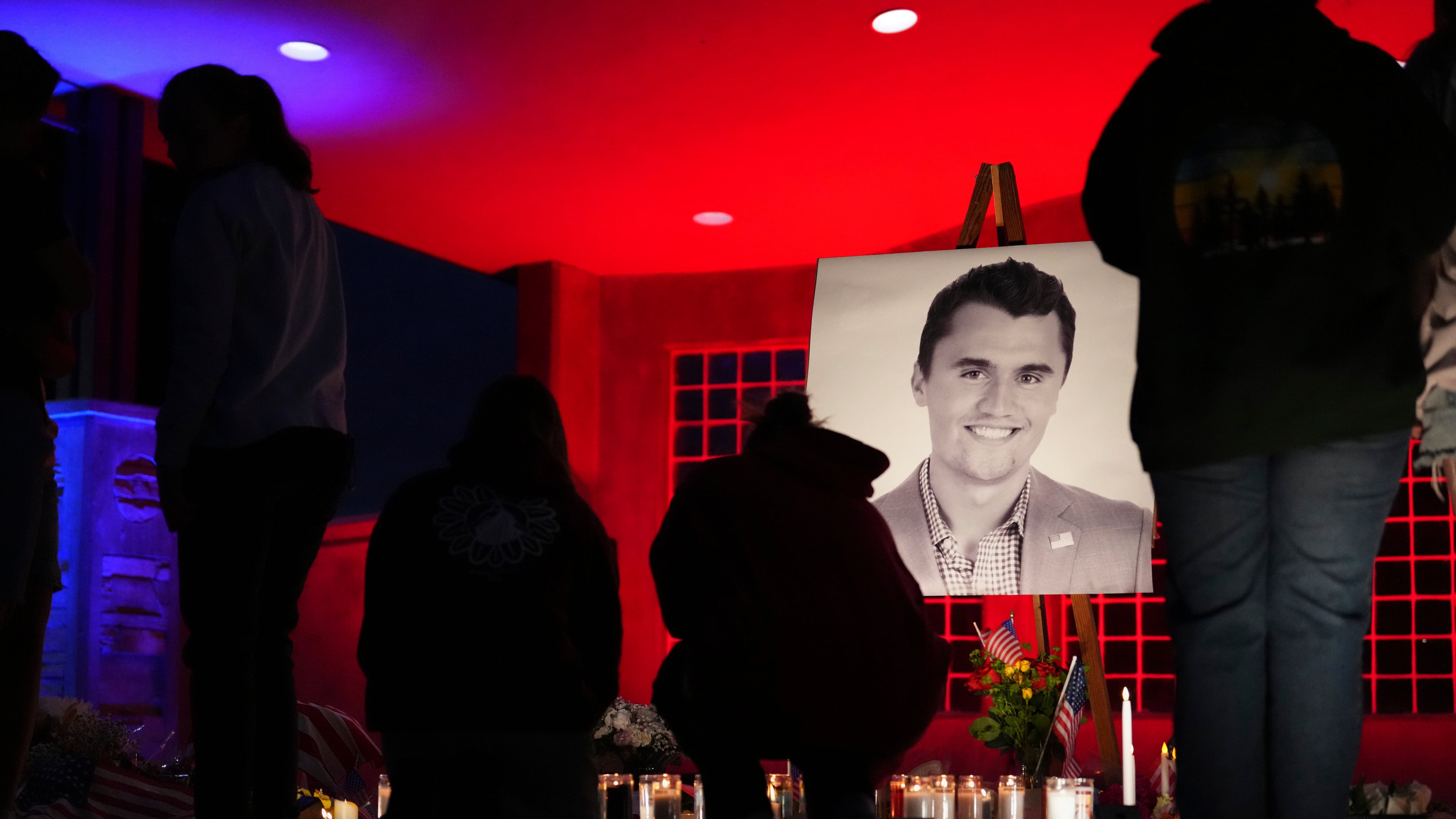People place lit candles below a photo of Charlie Kirk, the CEO and co-founder of Turning Point USA who was shot and killed, at a vigil in his memory, Thursday, Sept. 11, 2025, in Orem, Utah. (AP Photo/Lindsey Wasson)