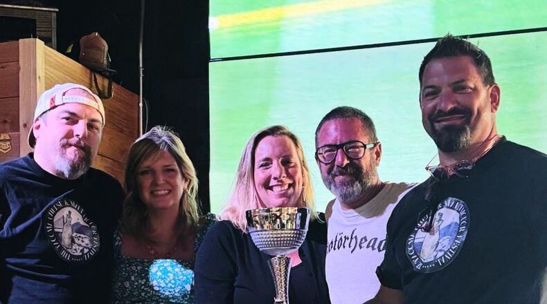 This photo provided by Kole Musgrove shows John Forsberg, far right, holding a trivia championship trophy and poses for a photo with other members of his team at Ashtown Brewing Company in Longview, Wash, on July 1, 2025. (Kole Musgrove via AP)