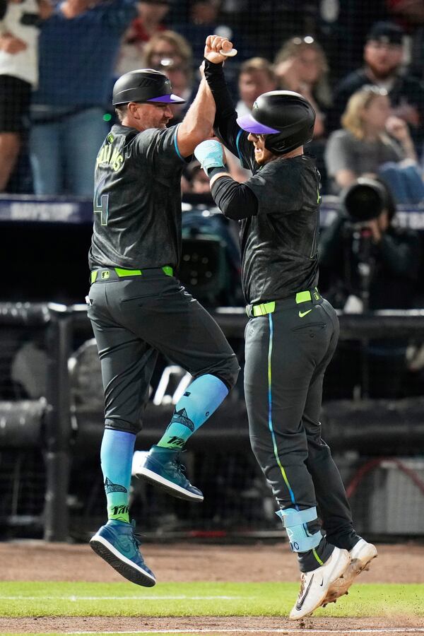 Tampa Bay Rays' Danny Jansen, right, celebrates his two-run home run off Atlanta Braves pitcher Bryce Elder with third base coach Brady Williams during the fourth inning of a baseball game Friday, April 11, 2025, in Tampa, Fla. (AP Photo/Chris O'Meara)