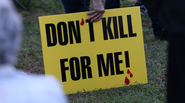 A death penalty opponent holds a sign outside the Georgia Diagnostic and Classification State Prison in Butts County during a protest in March 2016. The state's execution chamber is located at the prison.