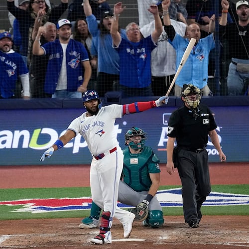 Toronto Blue Jays' Vladimir Guerrero Jr. watches his solo home run take flight against the Seattle Mariners during the fifth inning in Game 6 of baseball's American League Championship Series, Sunday, Oct. 19, 2025, in Toronto. (AP Photo/David J. Phillip)