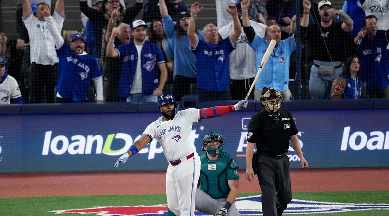Toronto Blue Jays' Vladimir Guerrero Jr. watches his solo home run take flight against the Seattle Mariners during the fifth inning in Game 6 of baseball's American League Championship Series, Sunday, Oct. 19, 2025, in Toronto. (AP Photo/David J. Phillip)