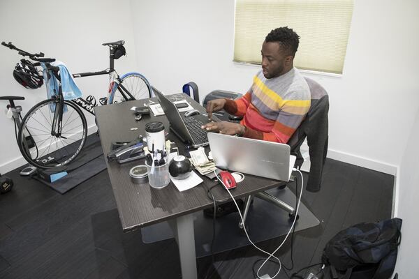 Banji Oyebisi works out of his home in Sandy Springs. He worked his way up from washing dishes at a local steakhouse to employing four people at his own technology consulting business. He pays state and federal taxes and hopes to expand his company one day. Photo by John Amis.