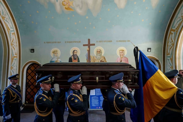An honor guard carries the coffin of Ukrainian F-16 pilot Maksym Ustymenko, during a farewell ceremony in Kyiv, Ukraine, on Thursday, July 3, 2025. (AP Photo/Evgeniy Maloletka)