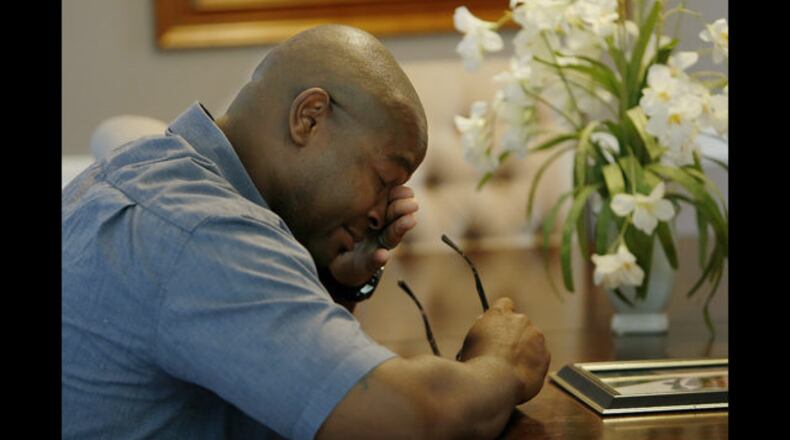 In this Friday, June 14, 2019 photo, Chris Parks looks at a portrait of his brother Donovan Corey Parks in Powder Springs, Ga. Marion Wilson Jr. and Robert Earl Butts Jr. were convicted of murder and sentenced to death in the March 1996 killing of 24-year-old Donovan Corey Parks. Butts was executed in May 2018. Wilson, who’s 42, was executed Thursday, June 20. (AP Photo/Andrea Smith)
