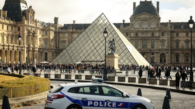 A police car parks in the courtyard of the Louvre museum, one week after the robbery, Sunday, Oct. 26, 2025 in Paris. The Paris prosecutor said on Sunday that a number of suspects have been arrested over the theft of crown jewels from Paris' Louvre museum last weekend. (AP Photo/Thomas Padilla)